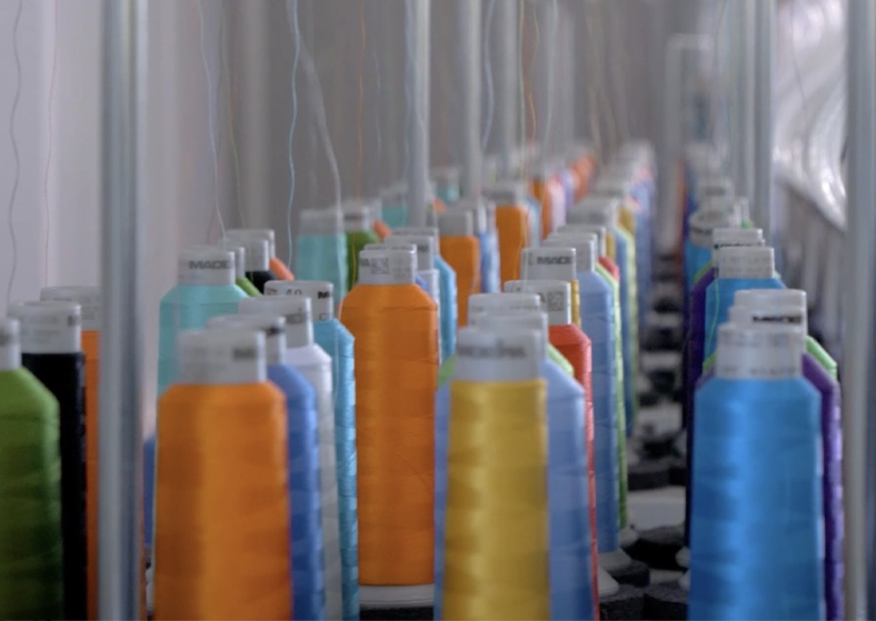 Enfilage des cônes de fils colorés sur machine à broder — Pen'Tee